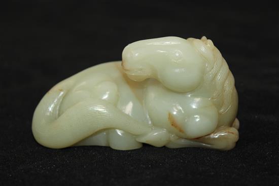 A Chinese celadon and brown jade figure of a recumbent horse, 20th century, 9.5cm